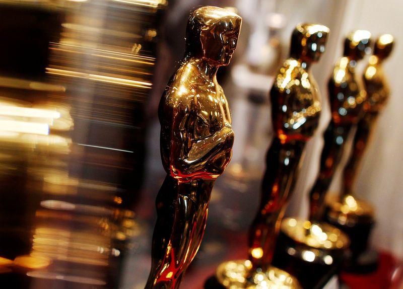 Qué sostiene la estatuilla de los Premios Oscar y que representa?