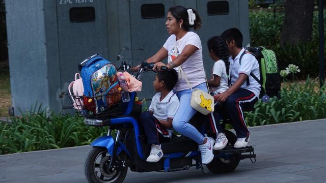 Una madre transporta a tres niños en una bicicleta eléctrica en el Bosque de Chapultepec