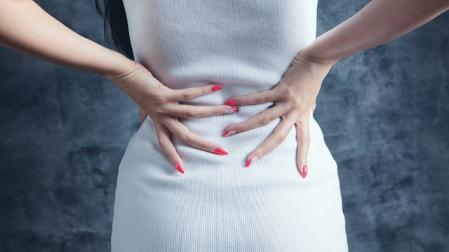 Mujer toca su cadera