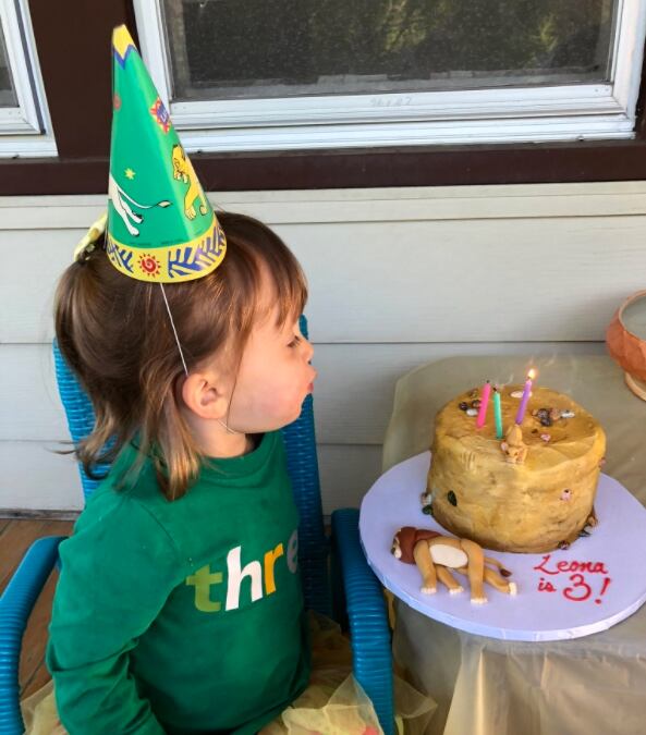 Niña soplando al pastel