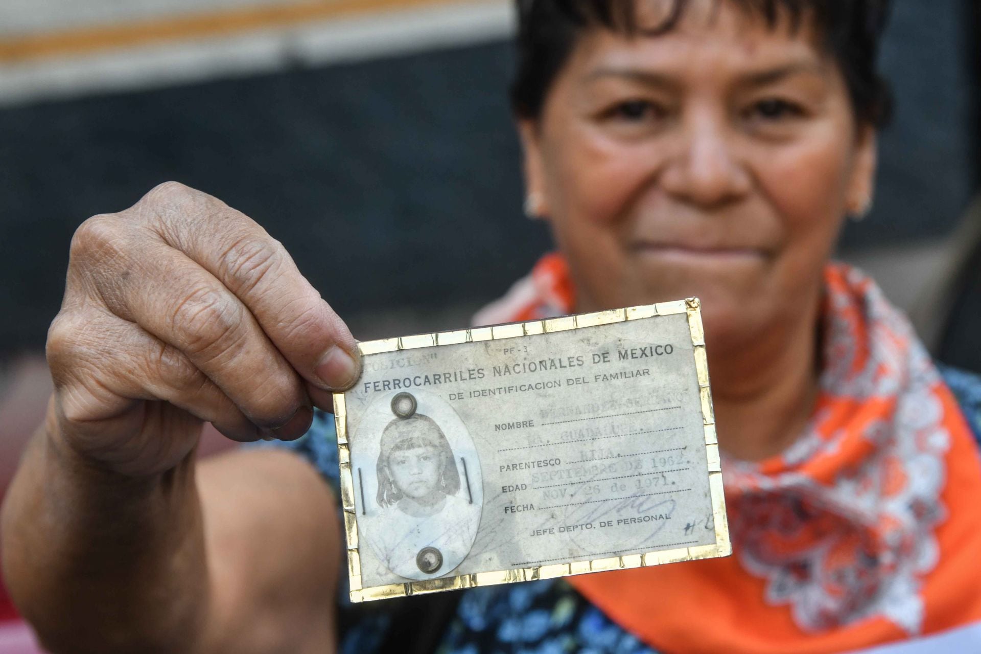 Guadalupe Hernández, hija de un operador de ferrocarril, muestra su credencial de identificación familiar por parte de Ferrocarriles Nacionales de México.