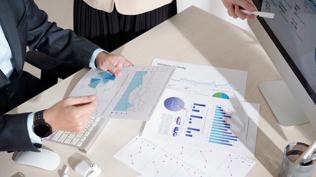 Business people working with chart and report showing performace of company and activity of its subdivisions