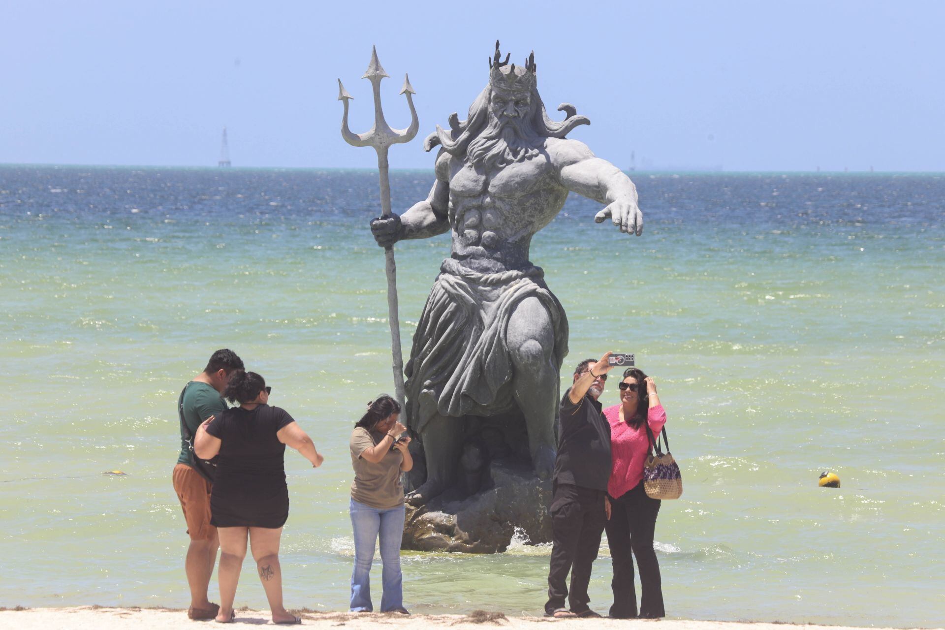 Turistas tomándose fotos con el Poseidón de Progreso