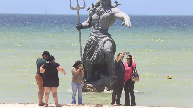 Turistas tomándose fotos con el Poseidón de Progreso