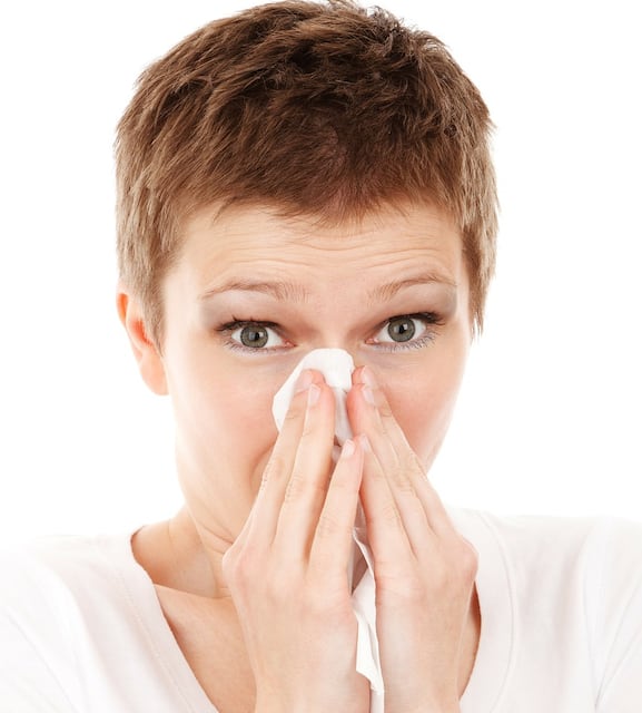 Mujer sonándose la nariz
