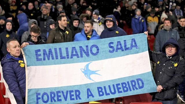Aficionados sostienen una manta en homenaje al futbolista argentino.
