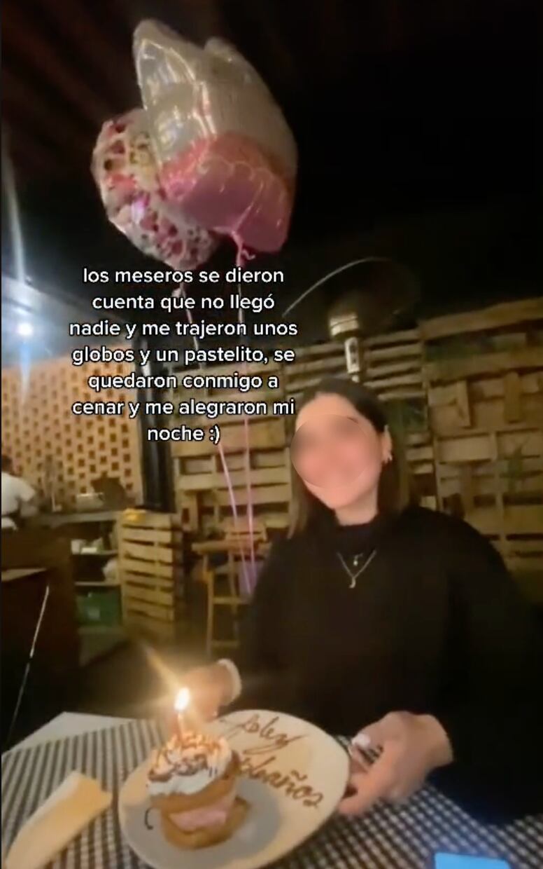 Joven con pastel de cumpleaños y globos