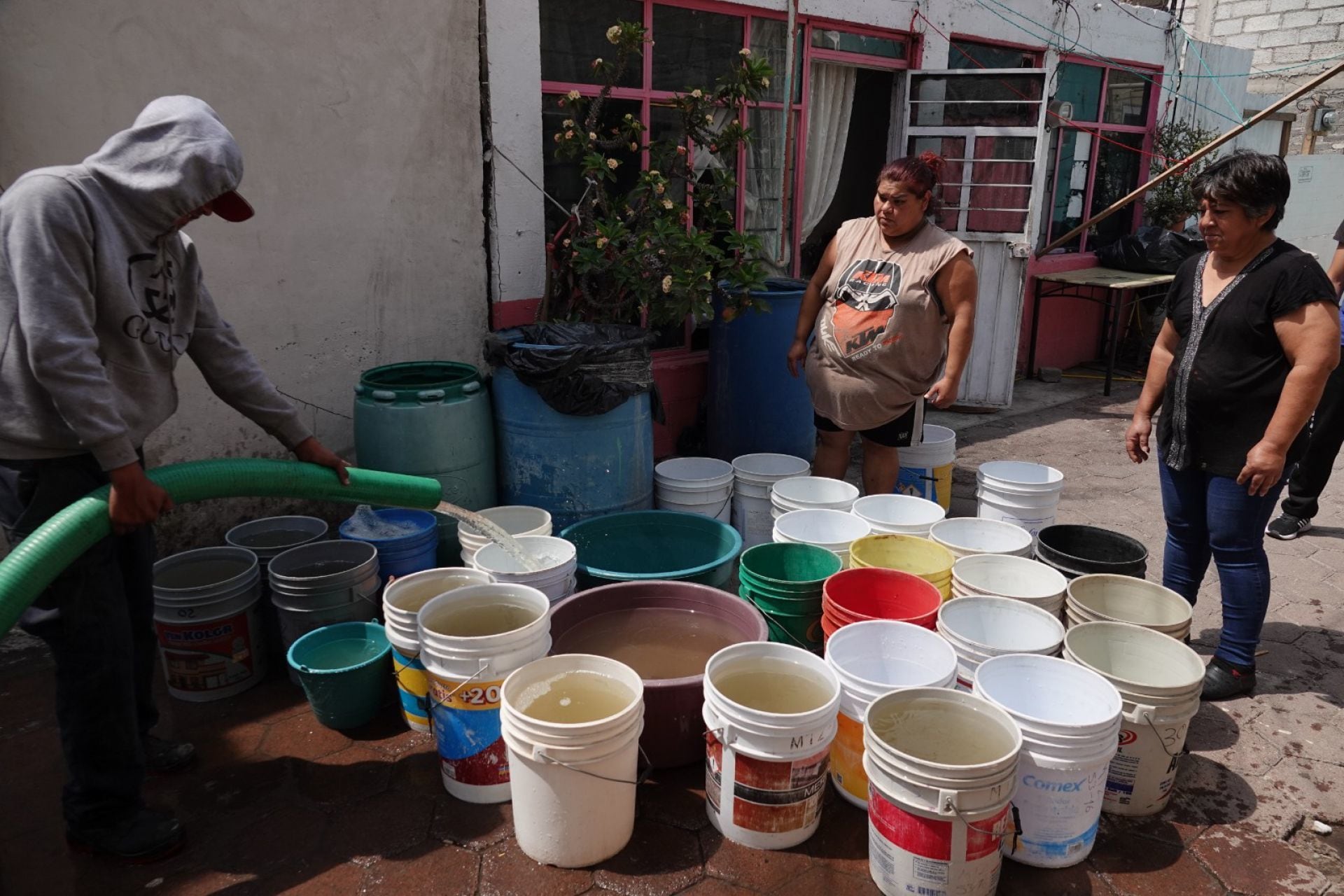 Familias de diferentes predios de la alcaldía Iztapalapa llenan botes y tambos de agua