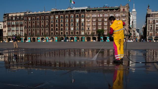 Un trabajador limpia la plancha del Zócalo capitalino.
