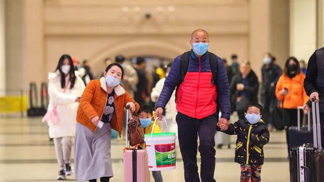 Varios pasajeros se protegen con mascarillas en la Estación de Tren de Hankou en Wuhan.