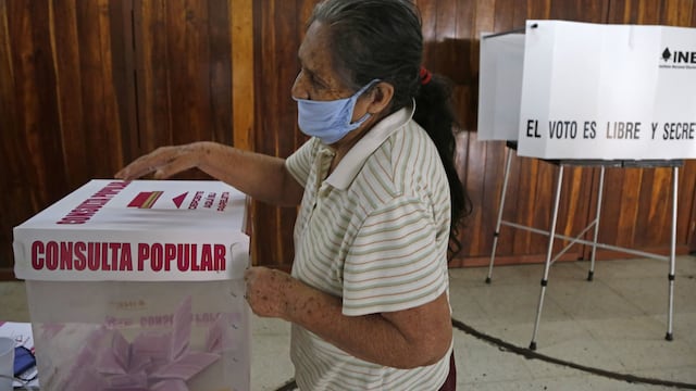 Una adulta mayor vota en la consulta popular.