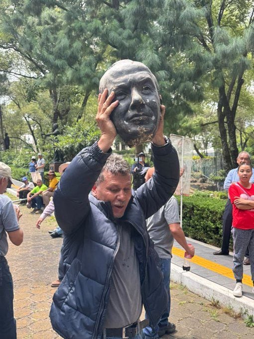 Extrabajadores de Luz y Fuerza cortan la cabeza a estatua de Felipe Calderón en Los Pinos