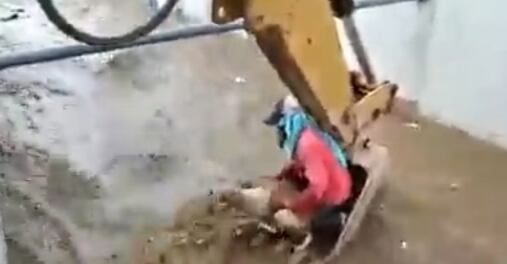 Trabajador rescatando a perrito que cayo en un canal de agua