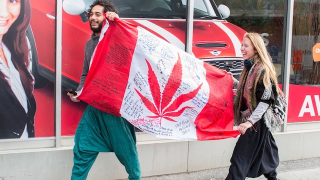 Ciudadanos canadienses portando una bandera. Celebración por legalización de la mariguana.