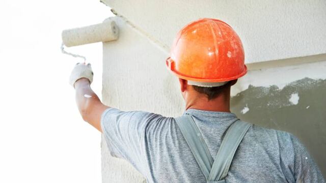 Trabajador pinta una vivienda.