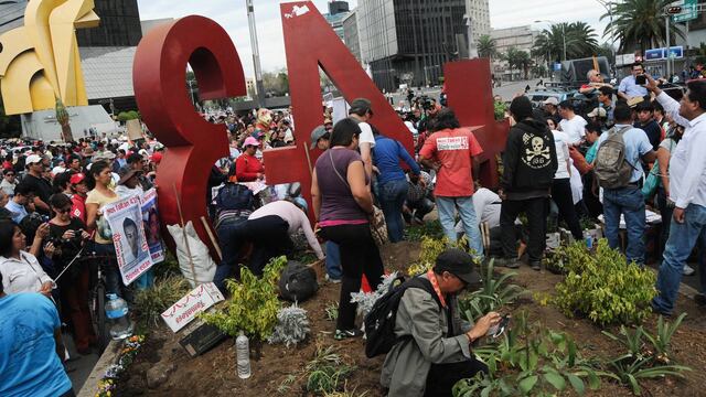 Padres de los 43 desaparecidos de Ayotzinapa plantan "no me olvides" en monumento