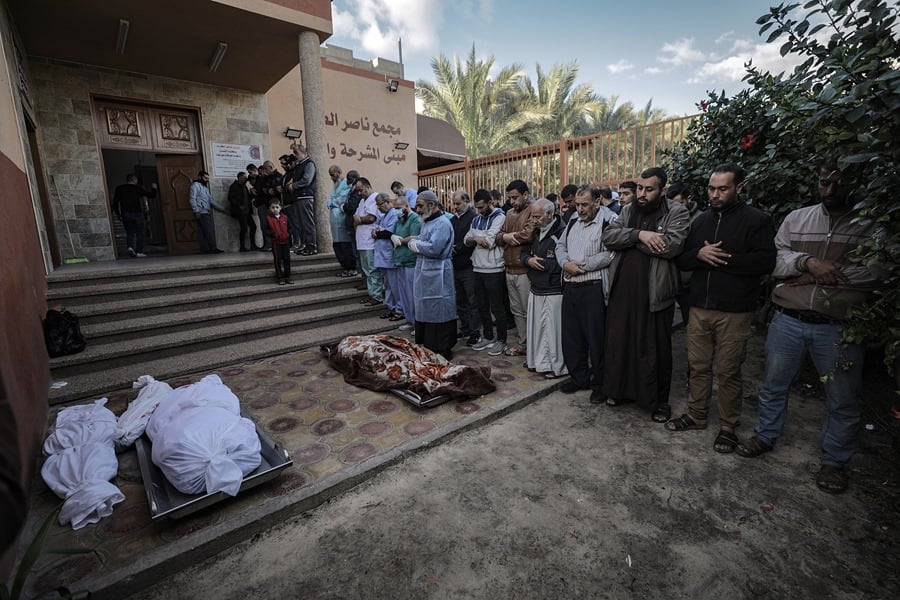 Personal del hospital y familiares de los palestinos que murieron tras los ataques aéreos israelíes contra un edificio que albergaba a personas desplazadas de la Franja de Gaza, rezan junto a sus cuerpos frente al Hospital Nasser en Jan Yunis, en el sur de la Franja de Gaza.
