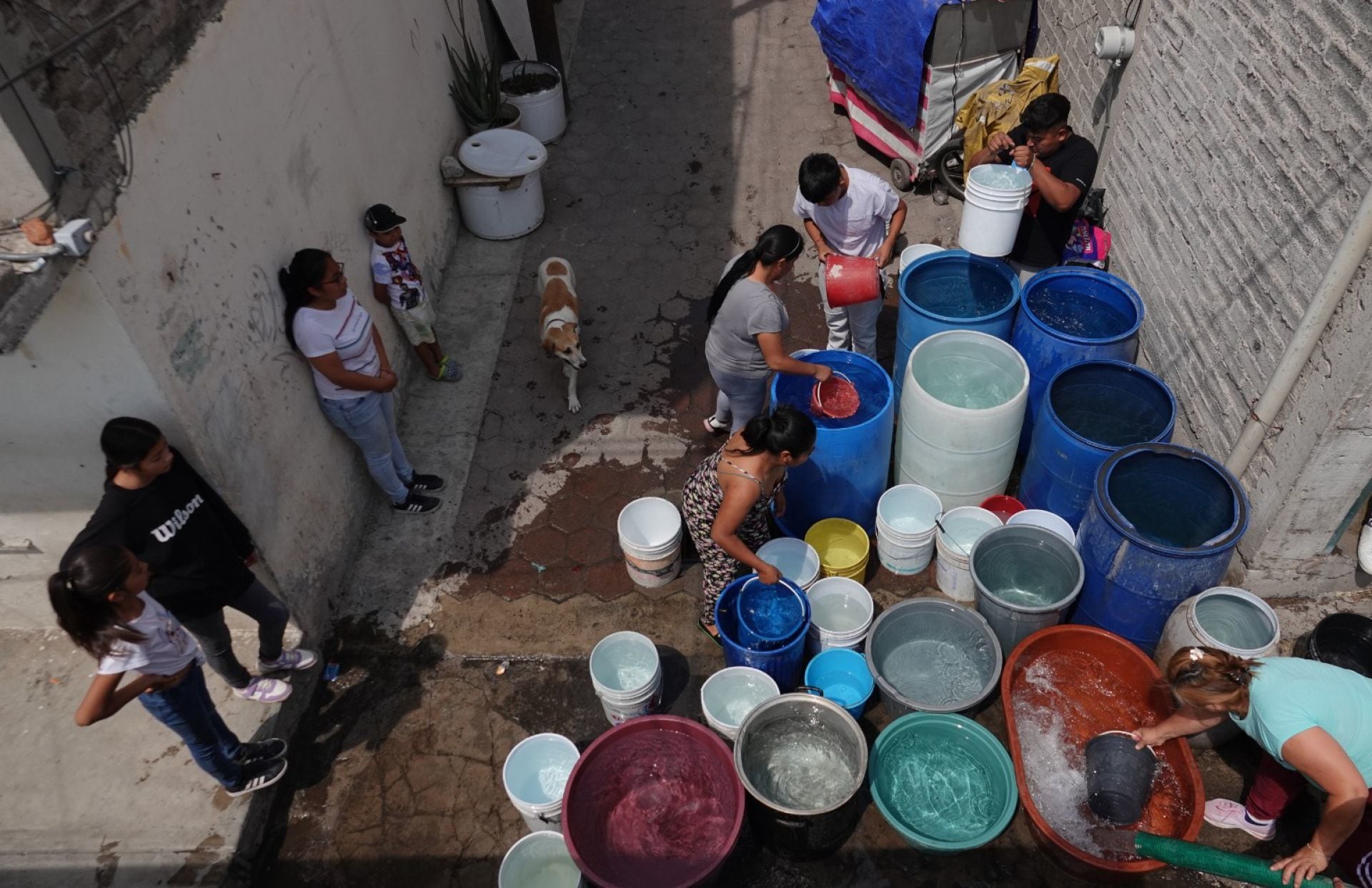 Vecinos de la colonia Degollado, en la alcaldía Iztapalapa, llenan botes y tambos que son suministrados por pipas de agua