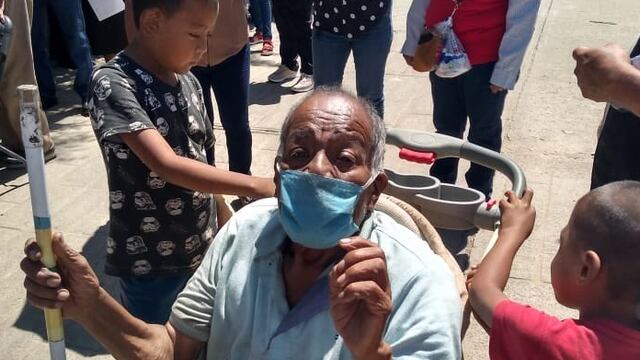 Niño lleva a vacunar a su abuelo, en Oaxaca