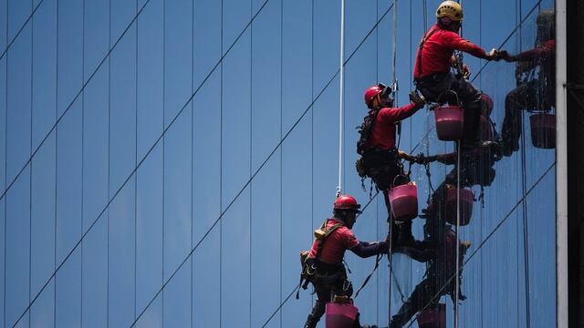 Tres limpiavidrios trabajan de manera sincronizada en el hotel Barceló sobre Paseo de la Reforma