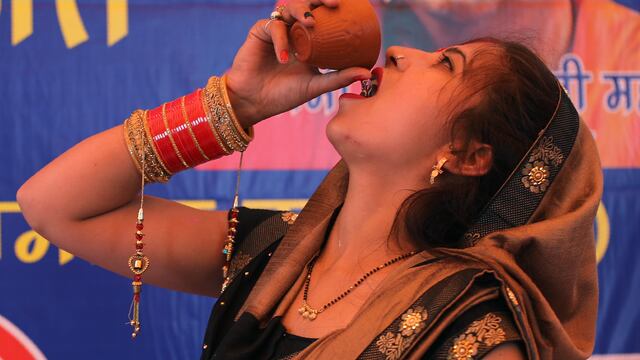 Una mujer bebe orina de vaca, considerada sagrada