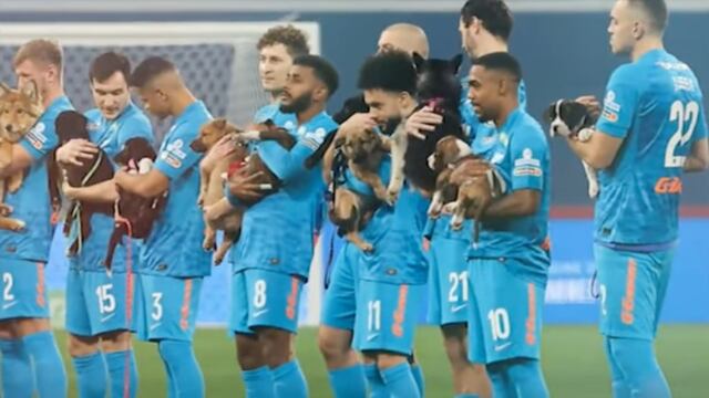 Jugadores de El Zenit salen al campo de juego cargando perritos