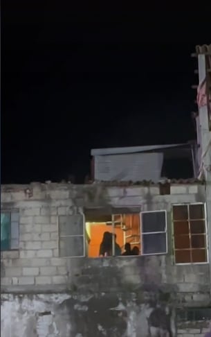 Familia disfrutando concierto desde la ventana de su casa