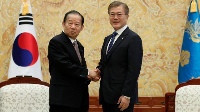 El Presidente Moon Jae-in con un funcionario nipón.