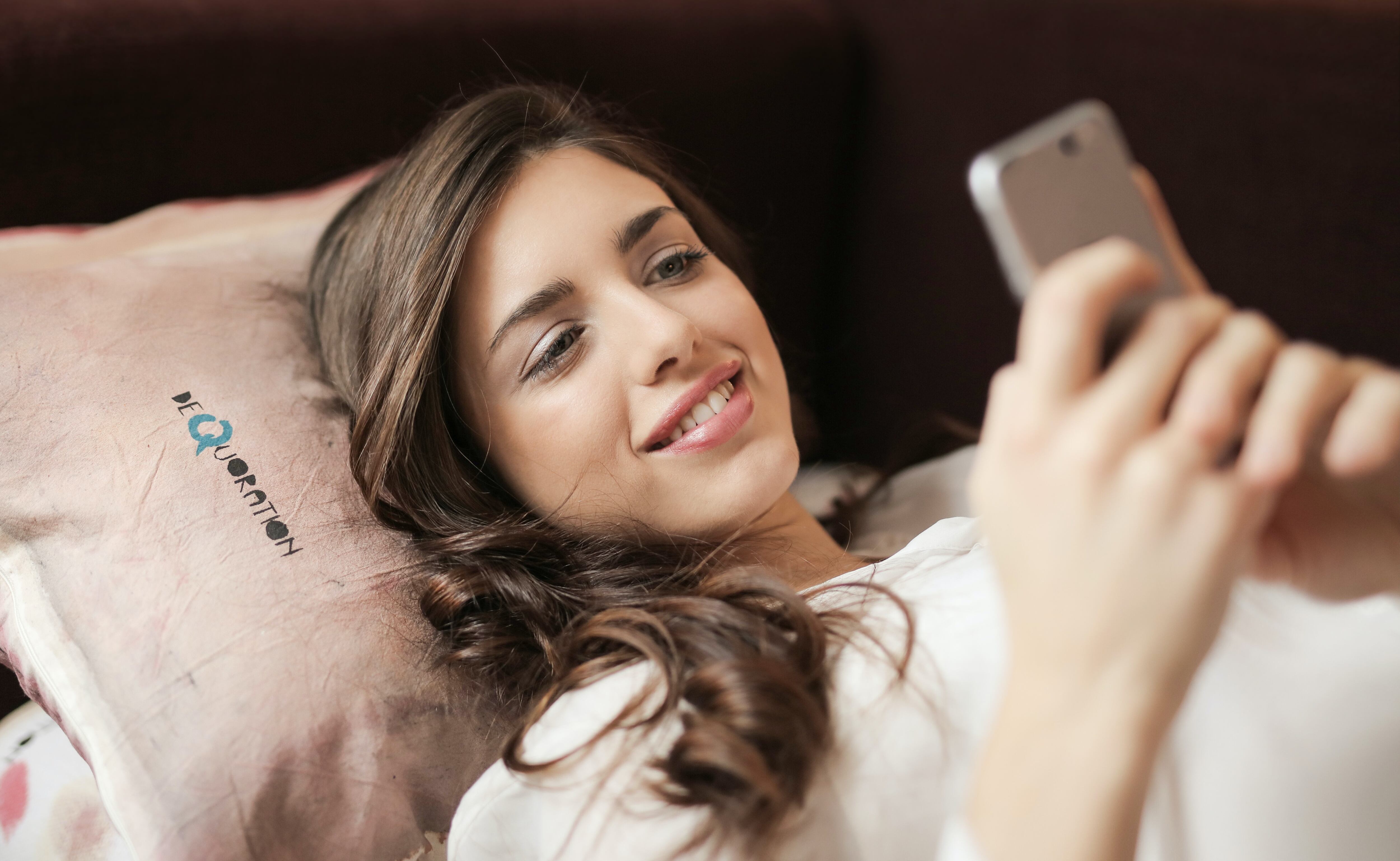 Mujer acostado viendo el celular