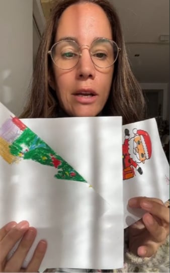 Mamá leyendo extraña carta a Santa Claus que escribió su hijo