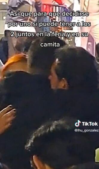 Joven agasajando con 2 hombres en la feria