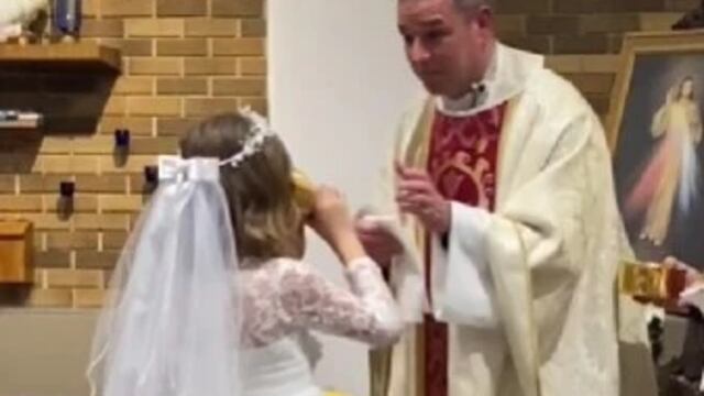 Niña se termina la copa de vino en su primera comunión