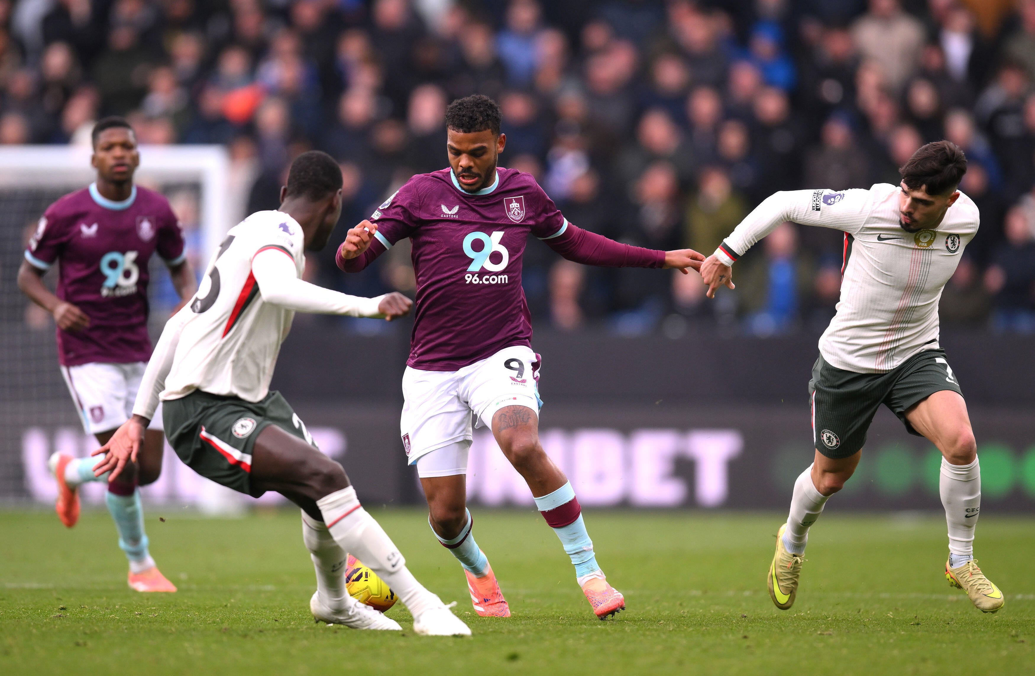 Burnley's Lyle Foster, centre, challenges for the ball during the English Premier League soccer match between Burnley v Chelsea, in Burnley, England, Saturday, Nov. 22, 2025. (Gary Oakley/PA via AP)