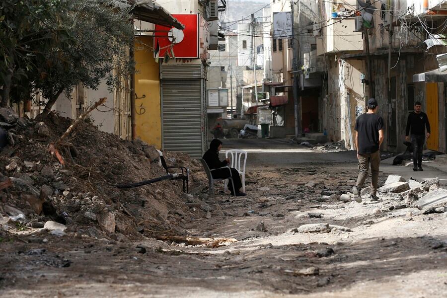 Varias personas caminan entre los escombros en una calle de Yenín, en Cisajordania ocupada, tras un incursión israelí