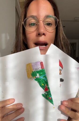 Mamá leyendo extraña carta a Santa Claus que escribió su hijo