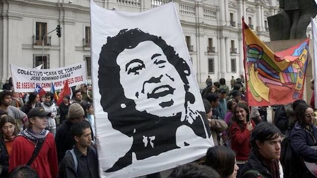 Manifestantes portan un cartel con la imagen del cantautor chileno Víctor Jara.