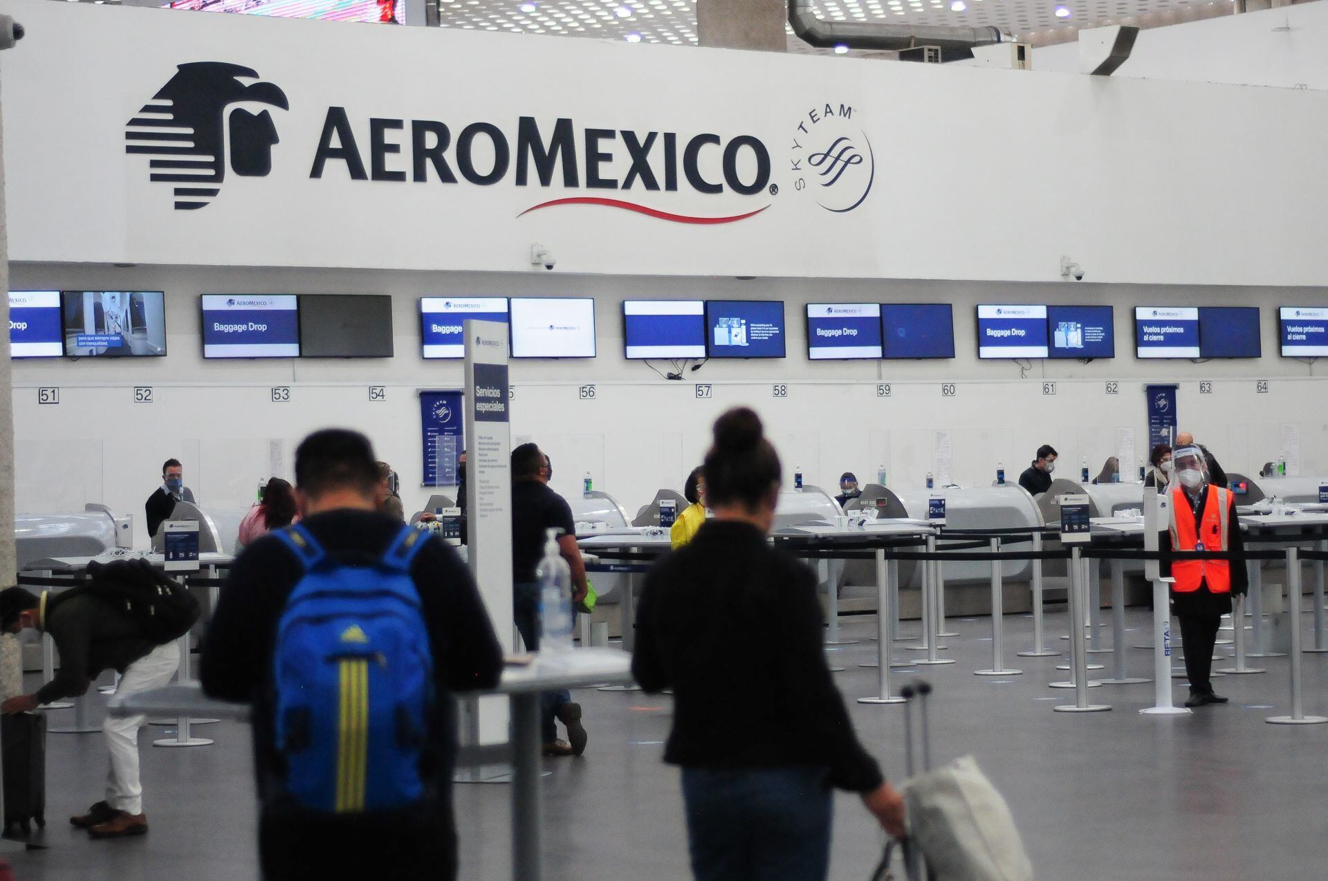 Pasajeros de la aerolínea Aeromexico pasan a ventanillas para recoger sus boletos