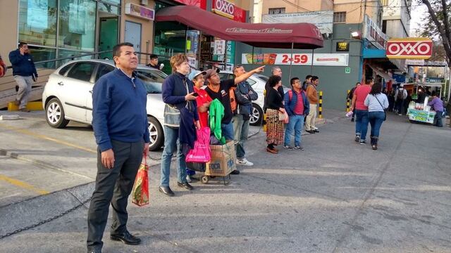 Transeuntes mirando la presencia de un objeto no identificado en el cielo de la Ciudad de México