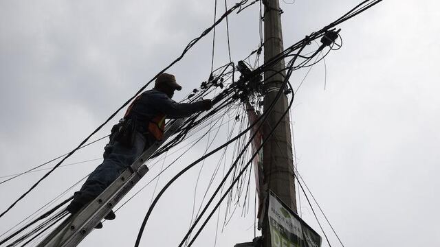 Un trabajador revisa el cableado que da servicios de voz y datos a un barrio de CDMX.