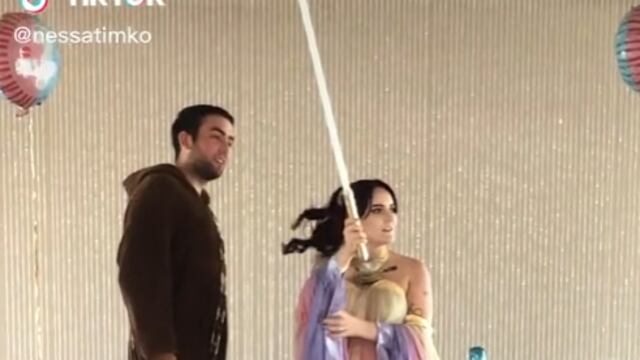 Pareja revelando género de su bebé con sable de luz de Star Wars