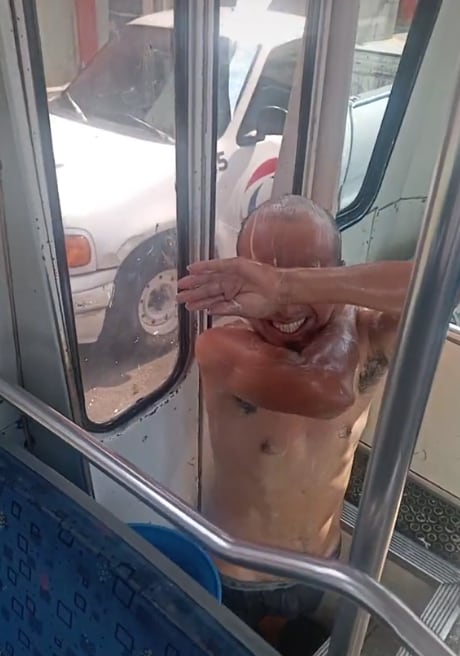 Chofer se da un baño dentro de su microbús