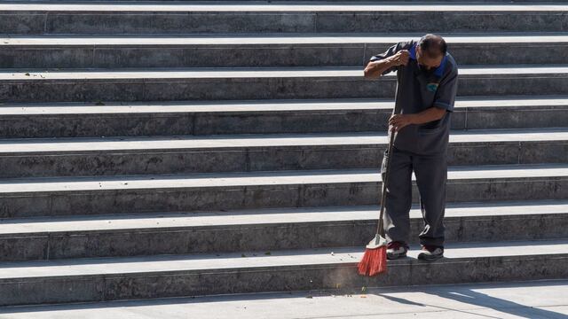Un trabajador de una empresa de limpieza barre las escaleras de la Estela de Luz