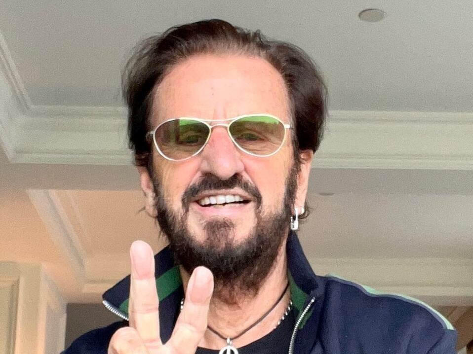 Ringo Starr haciendo su popular 'peace and love' con su mano.