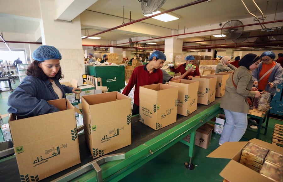 Voluntarios preparan cajas con alimentos para los palestinos de la Franja de Gaza, en un almacén del Banco de Alimentos de Egipto en Nuevo El Cairo