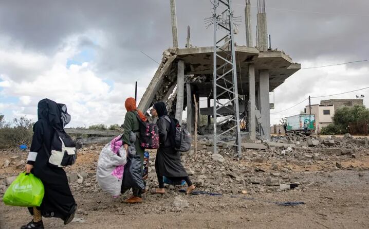 Mujeres palestinas caminan con sus pertenencias después de la orden de evacuación emitida por el ejército israelí, en Rafah, sur de la Franja de Gaza, este 6 de mayo