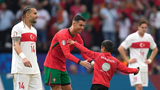 Cristiano Ronaldo con un niño que se metió al campo para pedirle una selfie.
