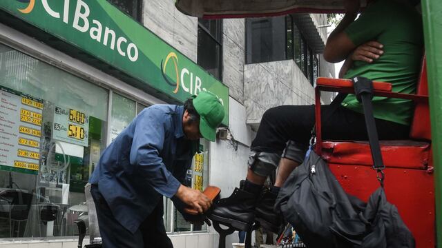 Un bolero realiza su trabajo enfrente de una sucursal de CiBanco