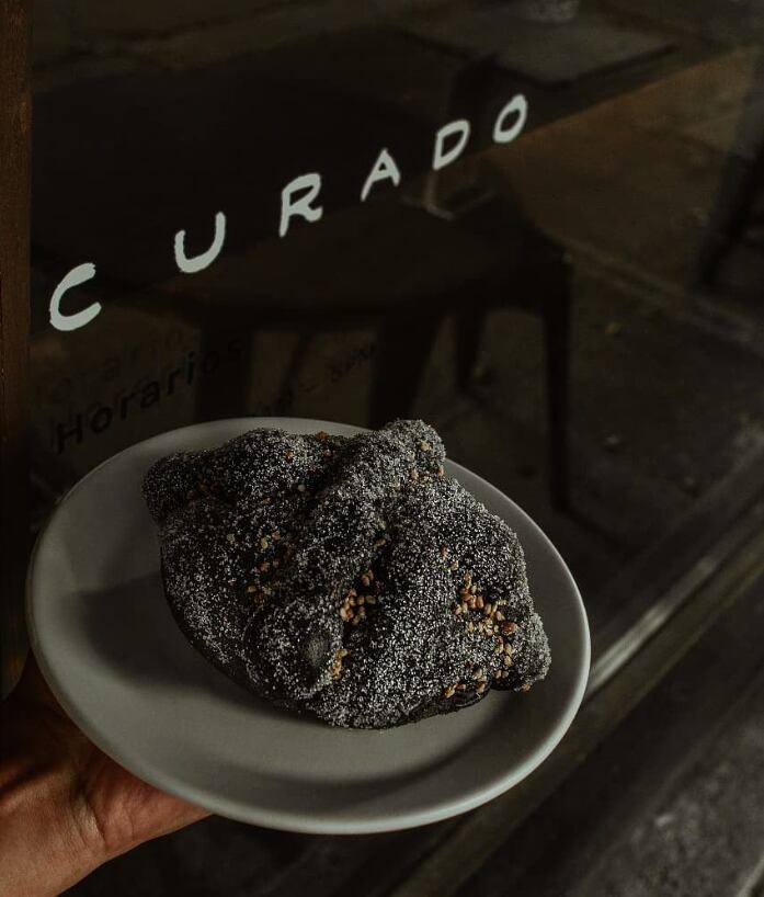 Pan de muerto con carbón activado, en Café Curado
