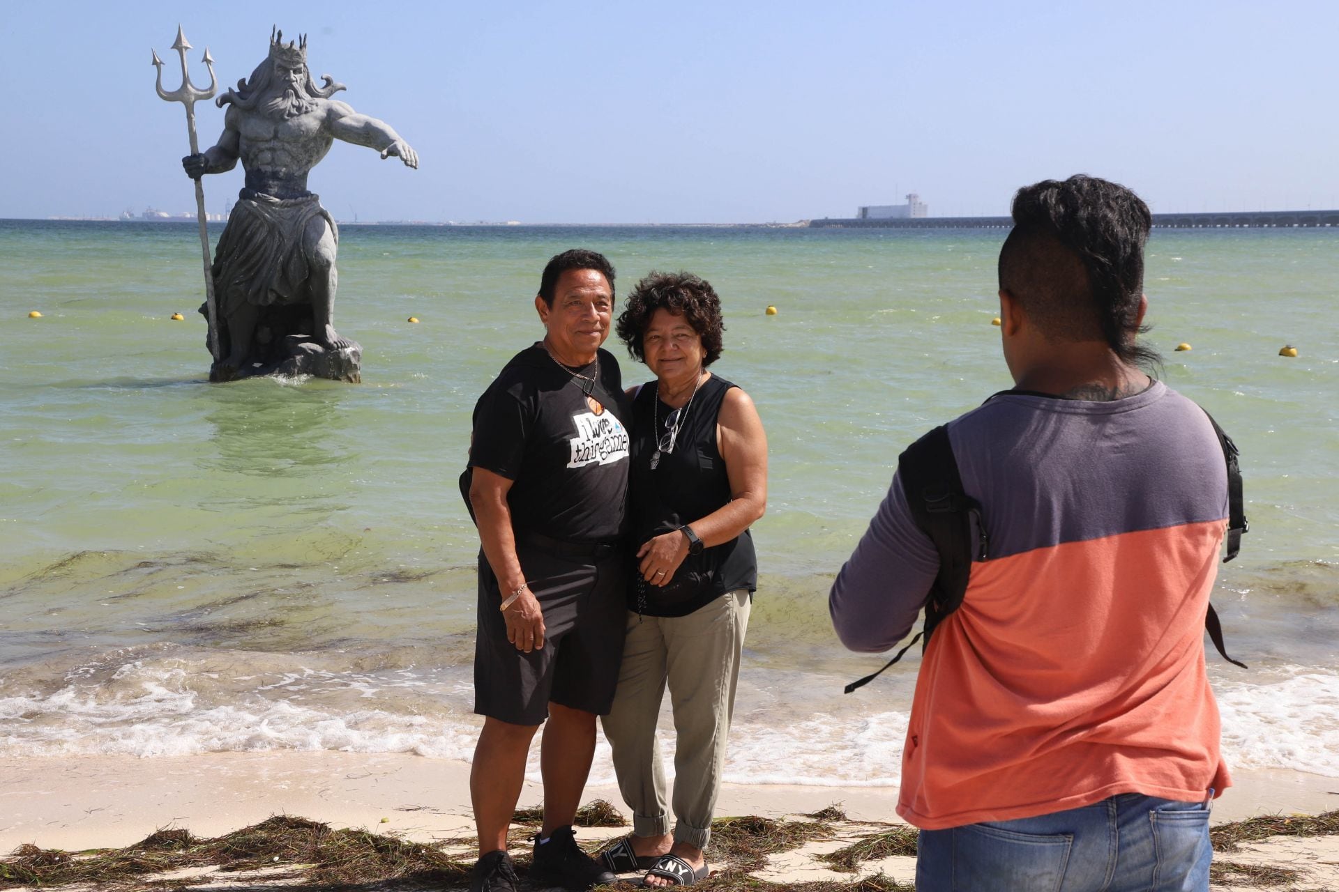 Turistas tomándose fotos con el Poseidón de Progreso