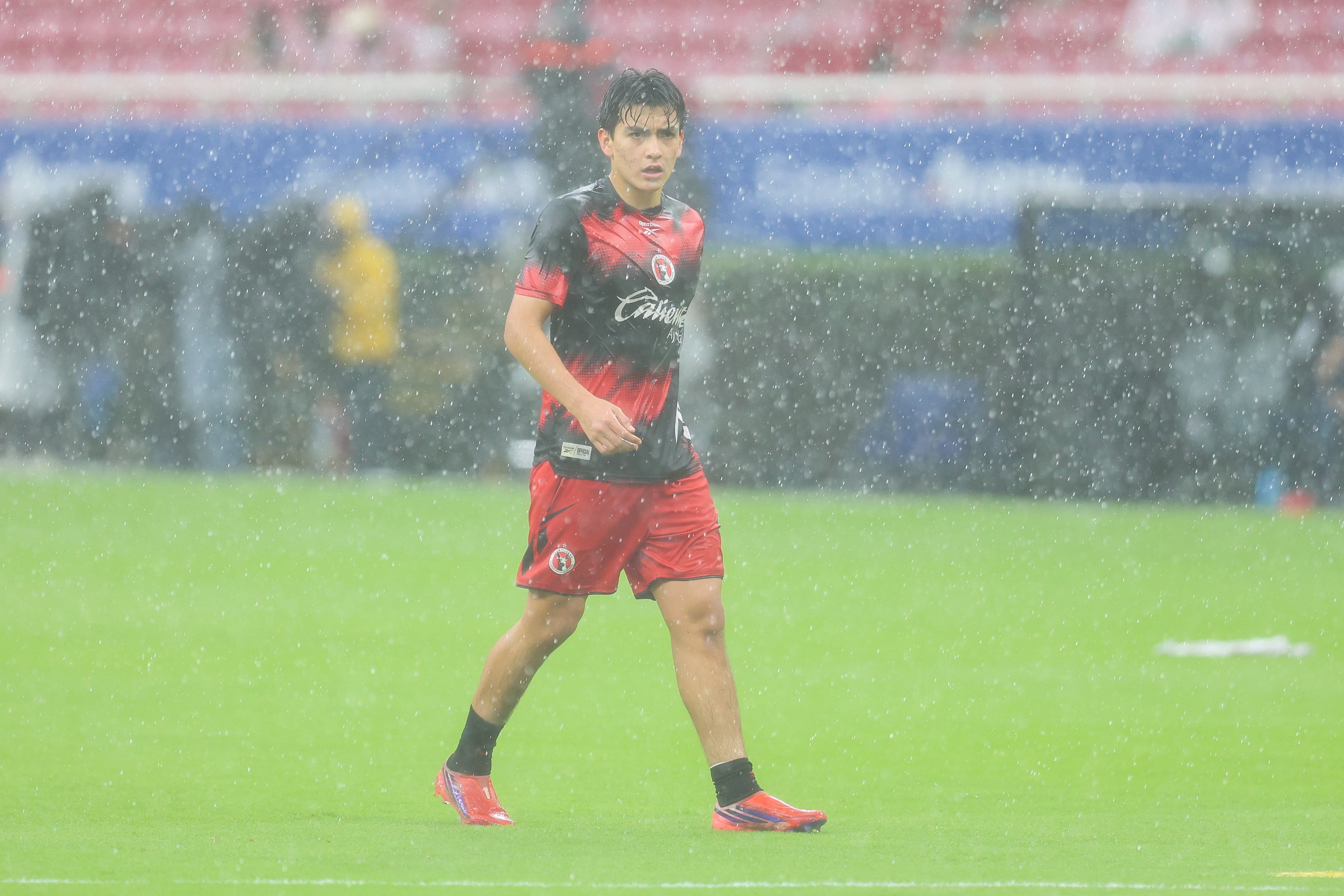 Gilberto Mora haciendo calentamiento bajo la lluvia